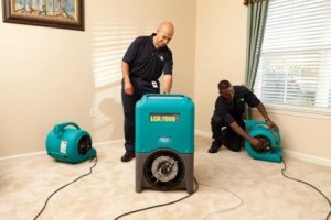 water damage restoration company drying out flood damage with industrial fans